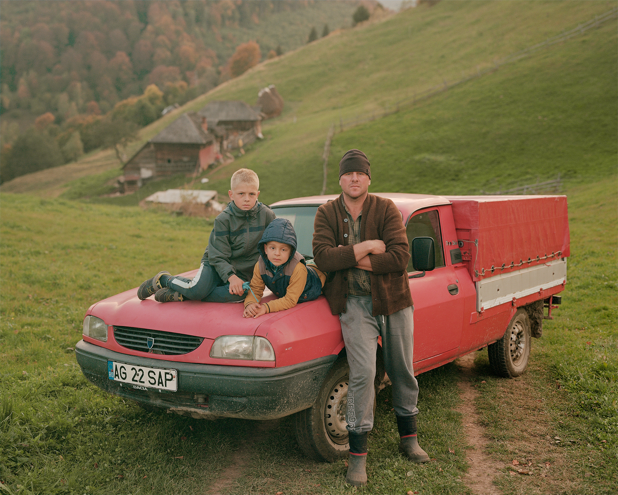 Ritratto di famiglia: padre e figli su un pick-up rosso, in un’area rurale di montagna, ph. Nicholas J.R. White